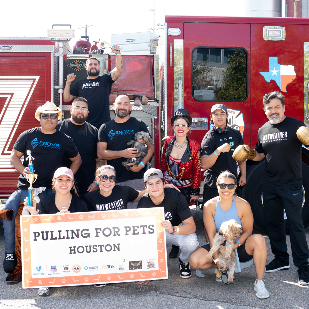 Team of people posing in front of fire truck from the 2022 Pulling for Pets event
