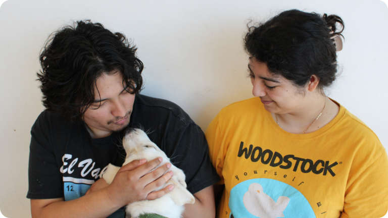 A pair look lovingly into their pups eyes
