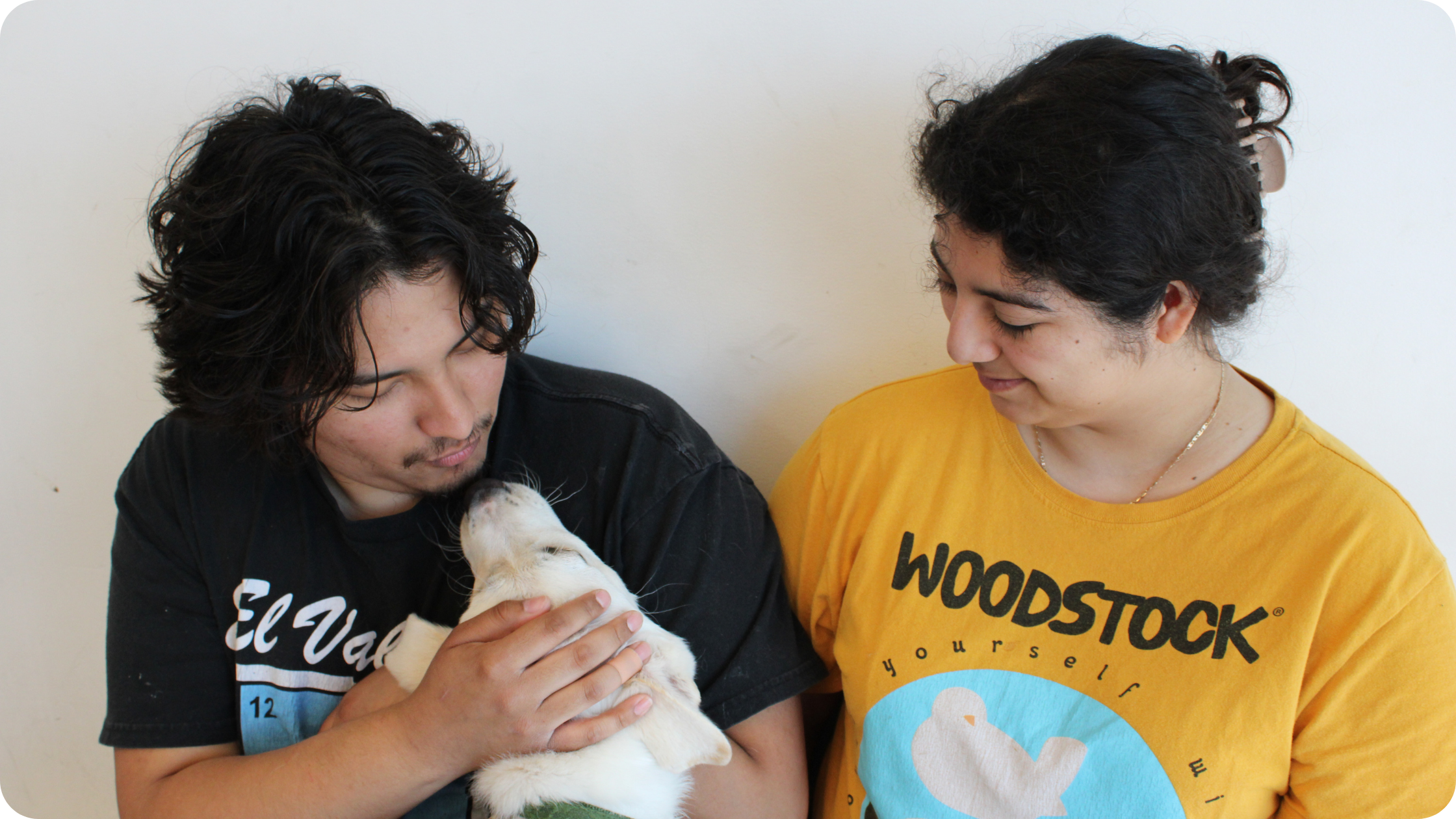 A pair look lovingly into their pups eyes